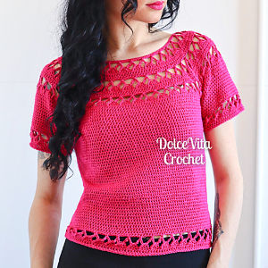 Une femme aux cheveux longs et foncés porte un haut rose vif à manches courtes, réalisé au crochet et orné de détails ajourés. L'inscription « Dolce Vita Crochet » figure sur le devant. Ce modèle de haut crochet gratuit à télécharger est parfait pour des looks d'été élégants.