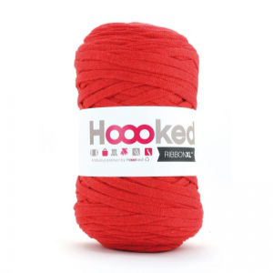 Une bobine de fil rouge épais avec une étiquette blanche indiquant Hoooked RibbonXL. Le fil est soigneusement enroulé en forme cylindrique.