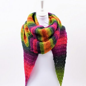 Un mannequin présente une grande écharpe triangulaire tricotée avec des rayures horizontales vibrantes dans les tons vert, jaune, orange, rose et violet, drapée élégamment autour du cou - une inspiration parfaite pour un tuto de châle au crochet facile.