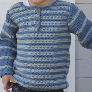 Un enfant portant un pull-over crocheté rayé bleu et gris clair à manches longues avec deux boutons près du col.