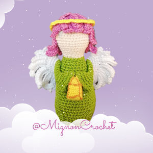 Poupée ange au crochet avec des cheveux roses, une auréole jaune, une robe verte et des ailes blanches, sur un fond violet parsemé de nuages. Le texte « @MignonCrochet » figure en bas.