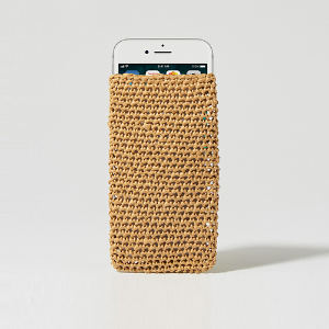 Un smartphone blanc, partiellement glissé dans pochette téléphone au crochet, posé à la verticale sur un fond blanc uni.